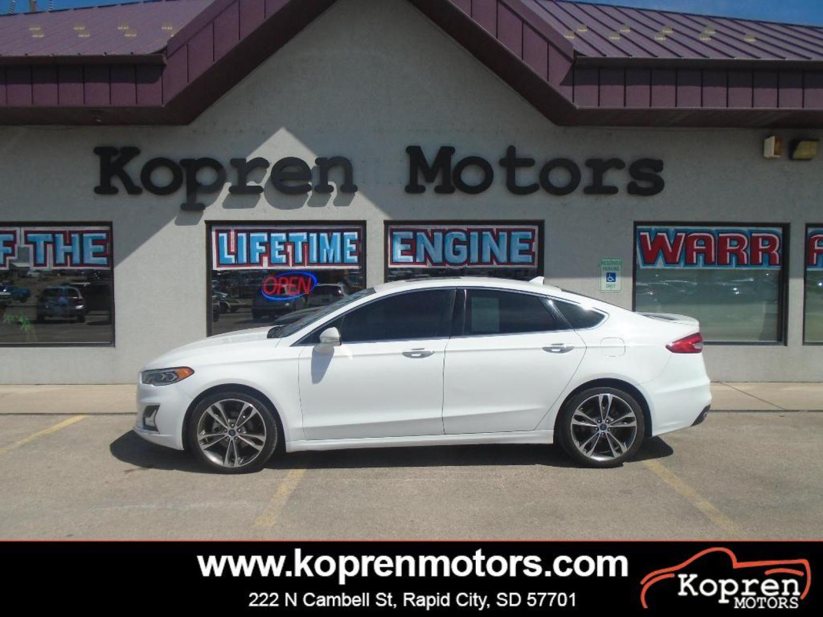 2019 Oxford White /Russet Ford Fusion Titanium (3FA6P0D98KR) with an L4, 2.0L engine, 6-speed automatic transmission, located at 222 N Cambell St., Rapid City, SD, 57701, (866) 420-2727, 44.081833, -103.191032 - <b>Equipment</b><br>The rear parking assist technology on this Ford Fusion will put you at ease when reversing. The system alerts you as you get closer to an obstruction. Keep your hands warm all winter with a heated steering wheel in the Ford Fusion . Protect it from unwanted accidents with a cut - Photo #0