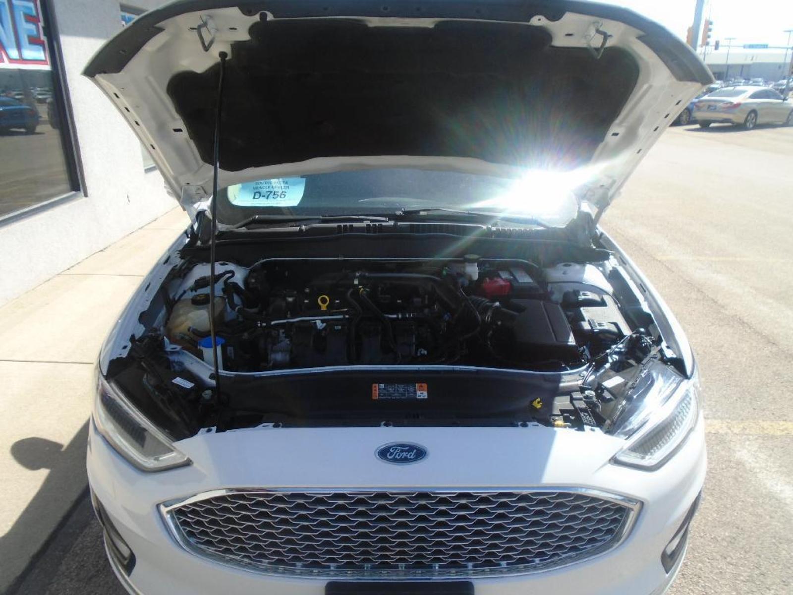2019 Oxford White /Russet Ford Fusion Titanium (3FA6P0D98KR) with an L4, 2.0L engine, 6-speed automatic transmission, located at 222 N Cambell St., Rapid City, SD, 57701, (866) 420-2727, 44.081833, -103.191032 - <b>Equipment</b><br>The rear parking assist technology on this Ford Fusion will put you at ease when reversing. The system alerts you as you get closer to an obstruction. Keep your hands warm all winter with a heated steering wheel in the Ford Fusion . Protect it from unwanted accidents with a cut - Photo #32
